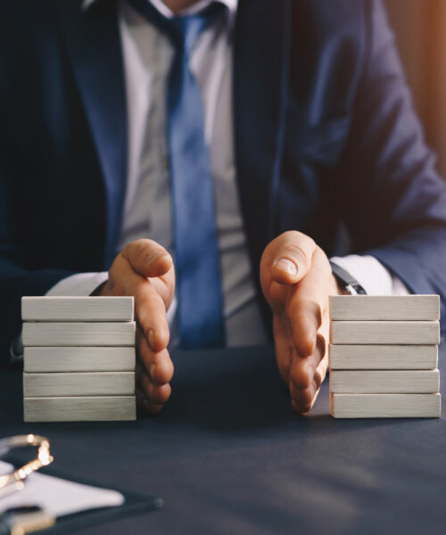 Businessman separates wooden block. Property division.
