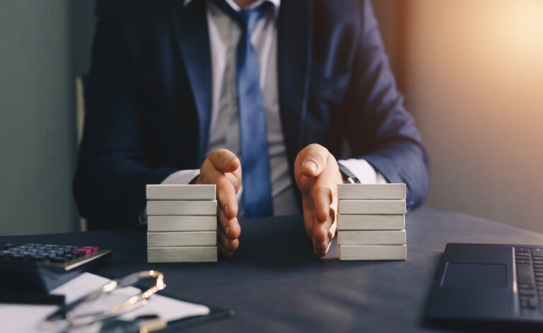 Businessman separates wooden block. Property division.