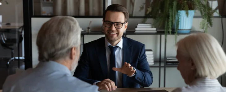 Happy confident lawyer, Real Estate Agent, notary, financial advisor giving consultation, legal advice to senior couple of clients about medical insurance, wills, house buying or selling, savings, investment