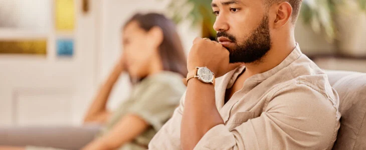 Divorce, sad and fight with couple on sofa for therapy, counselling and depression with conflict. Drama, fail and angry with man and woman in living room at home for fear, frustrated and decision